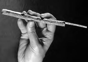 Eine Hand, die ein Stück Metall in der Hand hält.