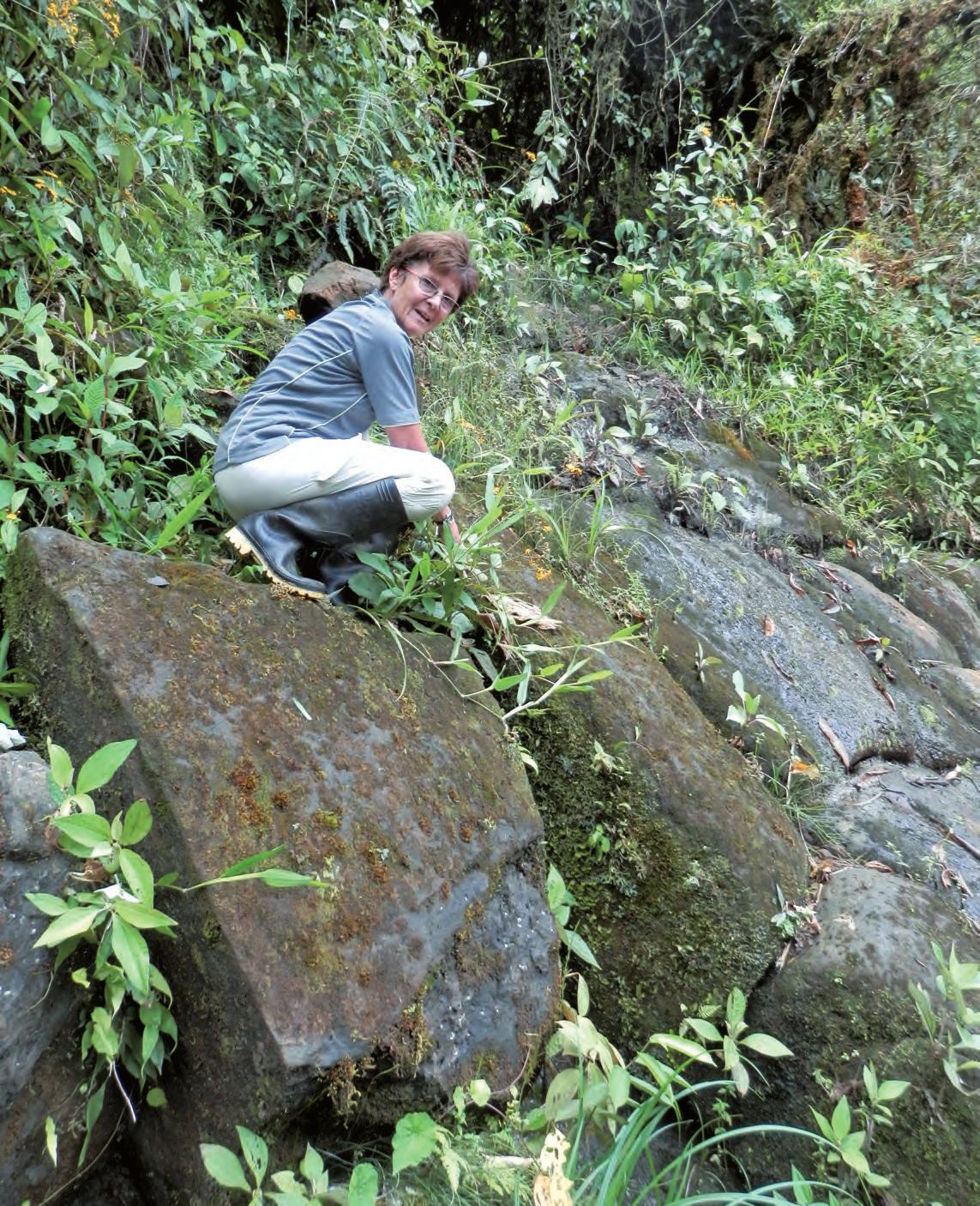 Eine Frau, die auf einem Steinweg kniet.
