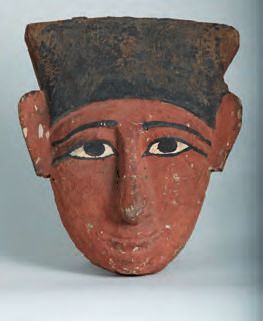 Eine Holzmask eines Mannes mit einem Hut auf dem Kopf.
