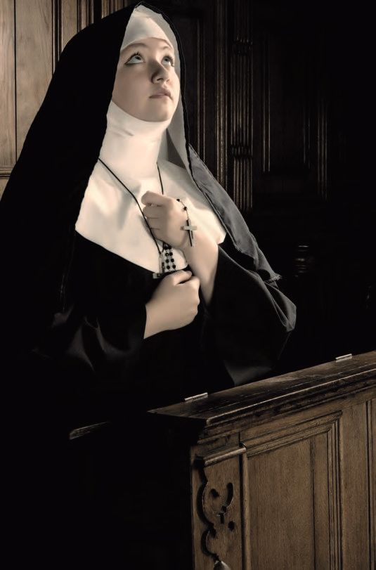 Eine Frau in einer Kirche in einem Nonnenkleid.