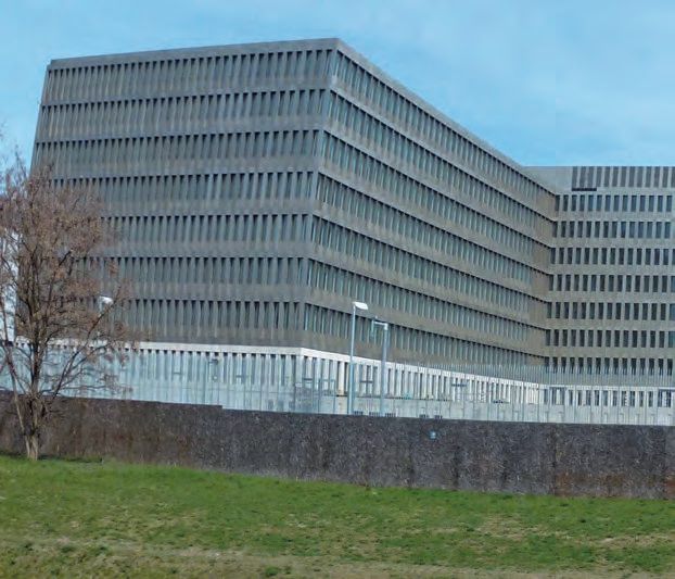 Ein großes Gebäude mit einem grasigen Bereich vor ihm.