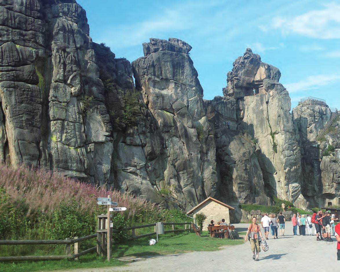 Eine Gruppe von Menschen geht auf einem Pfad vor einem Berg.