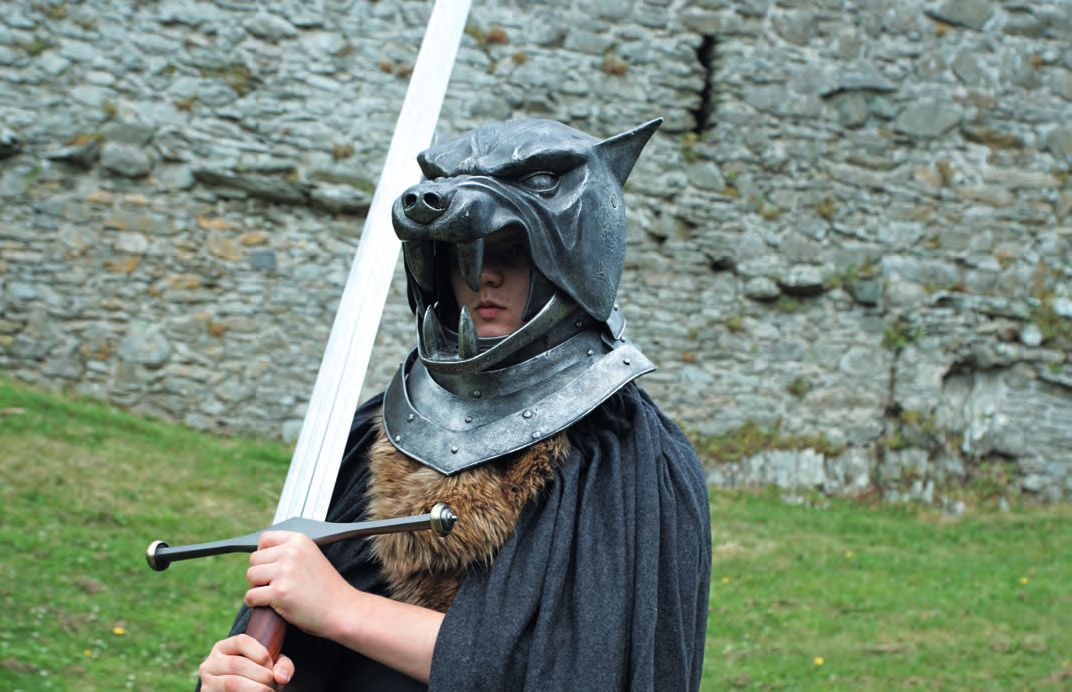 Eine Person in Kostüm, die ein Schwert hält und eine Maske trägt.