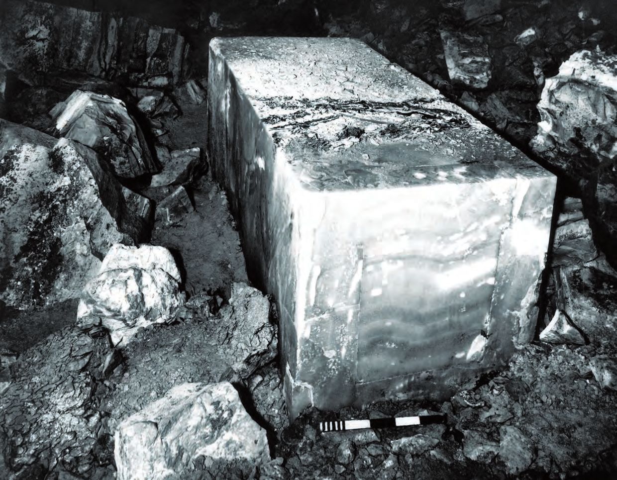 Ein großer Steinblock, umgeben von Felsen in einer Höhle.