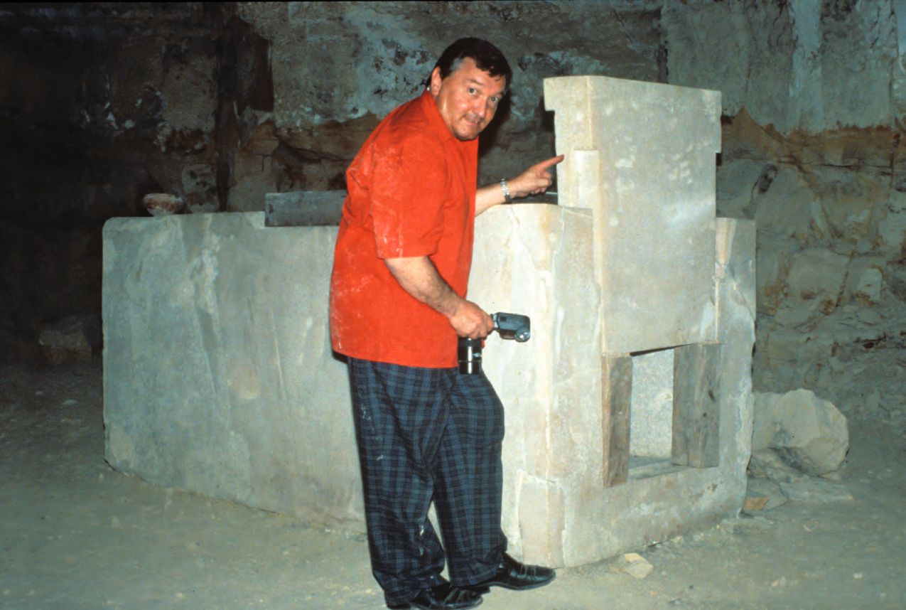 Ein Mann im roten Hemd hält einen Hammer.