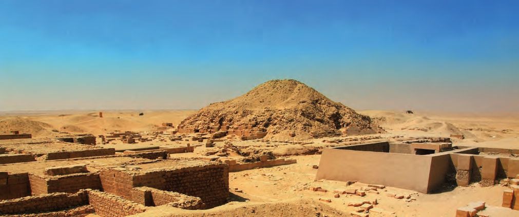 Eine Wüstenlandschaft mit einem Berg im Hintergrund.