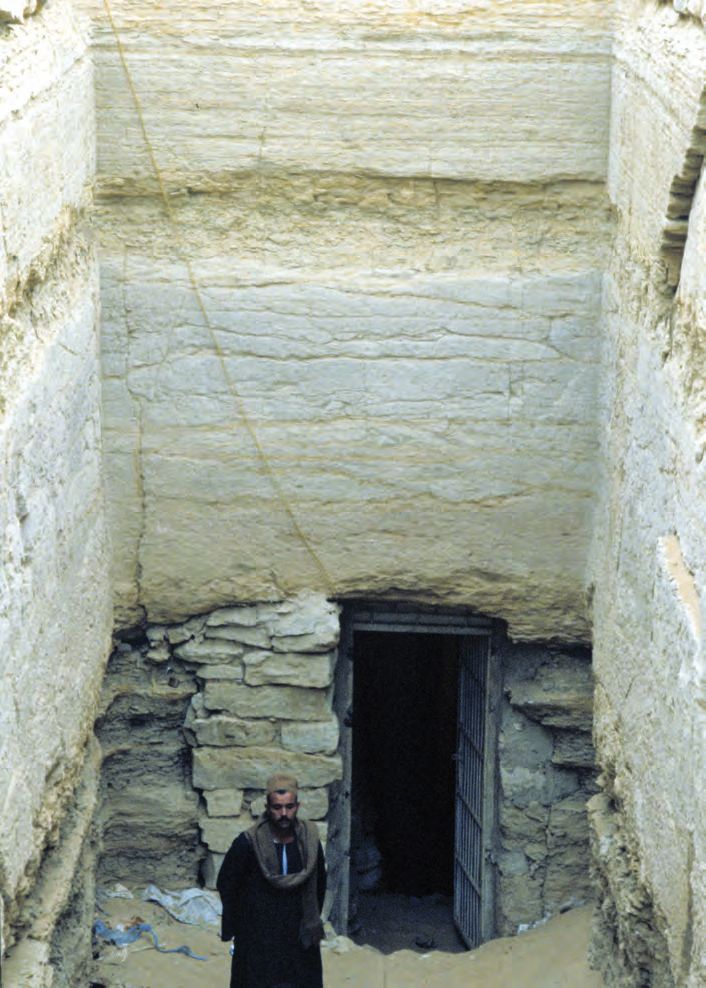Ein Mann, der in einer Höhle steht und durch eine Tür schaut.