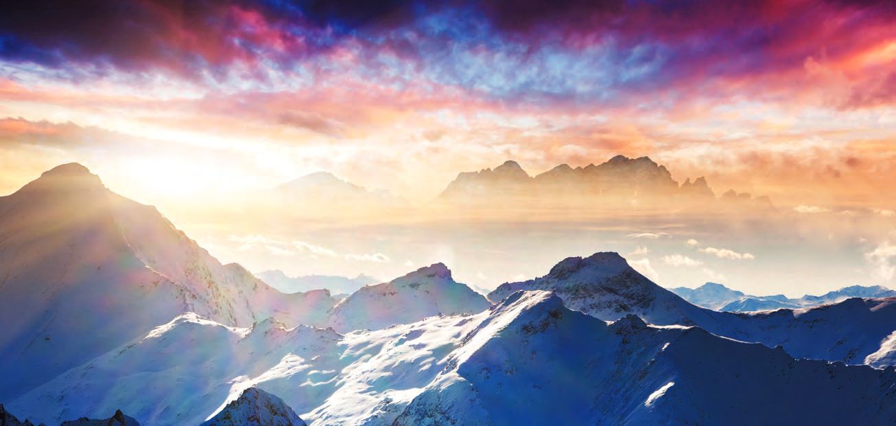Ein Bild eines Bergketten mit einem Sonnenuntergang im Hintergrund.
