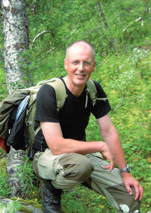 Ein Mann mit einem Rucksack stellt sich für ein Foto auf.
