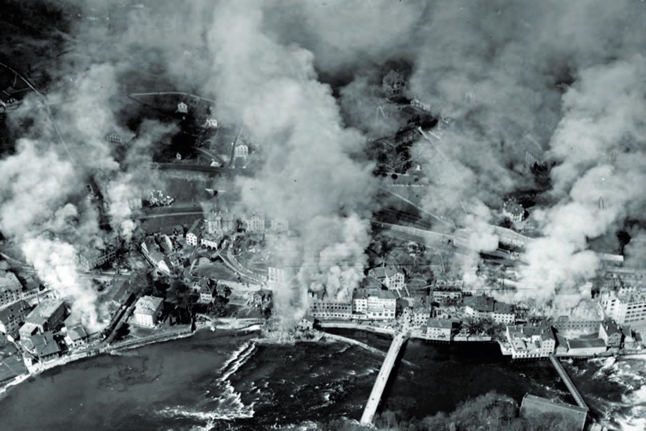 Ein schwarz-weißes Foto einer Stadt mit viel Rauch.