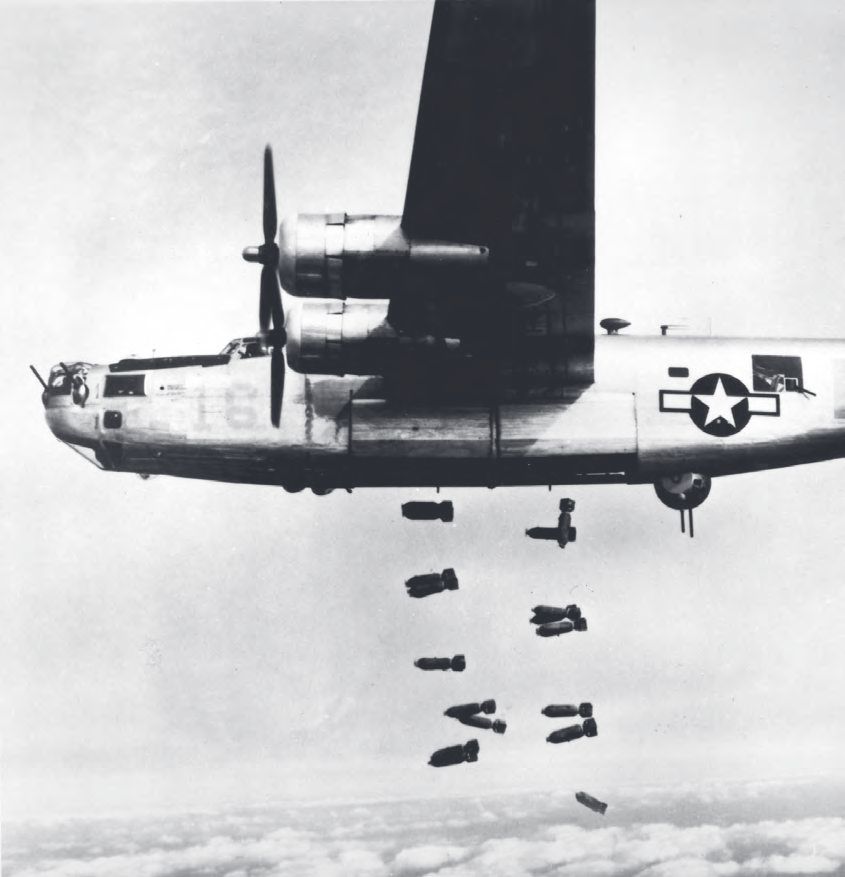 Ein Flugzeug, das im Himmel fliegt, mit einer Menge Bomben, die aus ihm kommen.