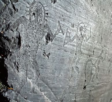 Eine Felswand mit Zeichnung von Menschen darauf.
