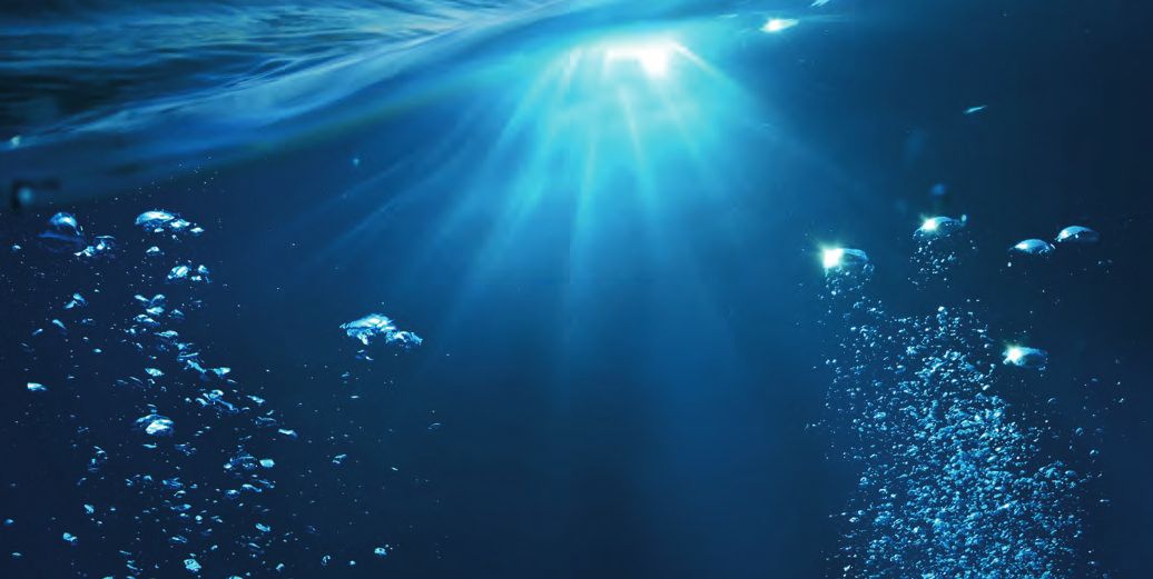 Ein helles Licht scheint durch das Wasser im Ozean.