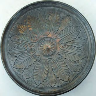 Ein rundes Metallobjekt mit einem Blumendesign.