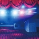 Ein Theater mit roten Vorhängen und hellen Lichtern.