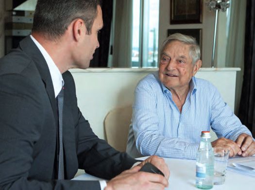 Zwei Männer sitzen an einem Tisch mit Wasserflaschen.