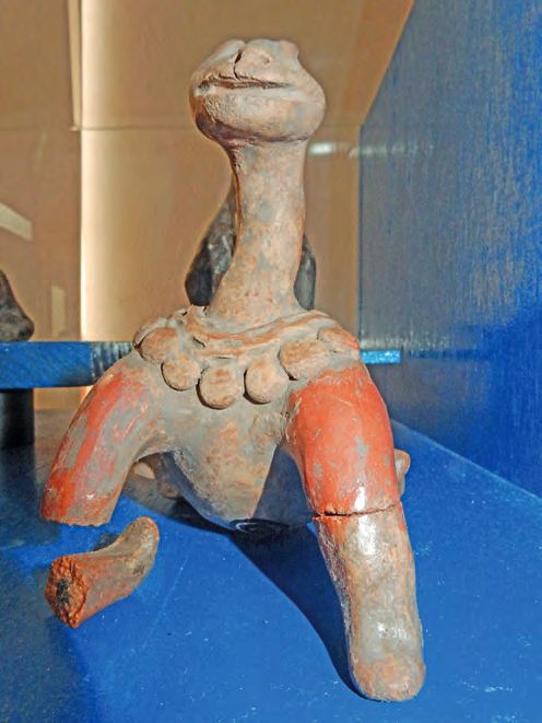 Eine Statue einer Giraffe, die auf einer blauen Oberfläche sitzt.