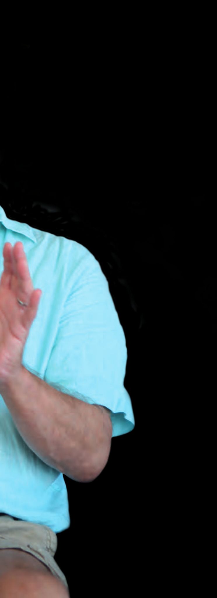 Ein Mann in einem blauen Hemd mit ausgestreckten Händen.