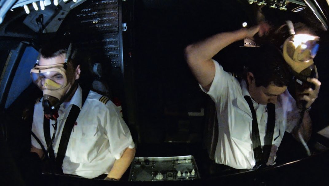Ein Mann in einem Cockpit mit einer Gasmaske.