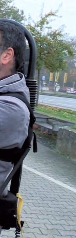 Ein Mann, der auf einem Stuhl auf einem Bürgersteig sitzt.