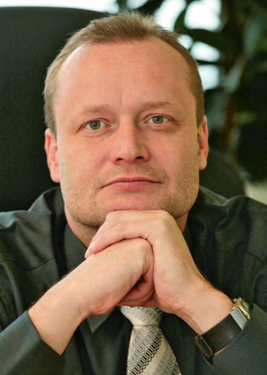 Ein Mann in Anzug und Krawatte, der die Hände zusammenhält.