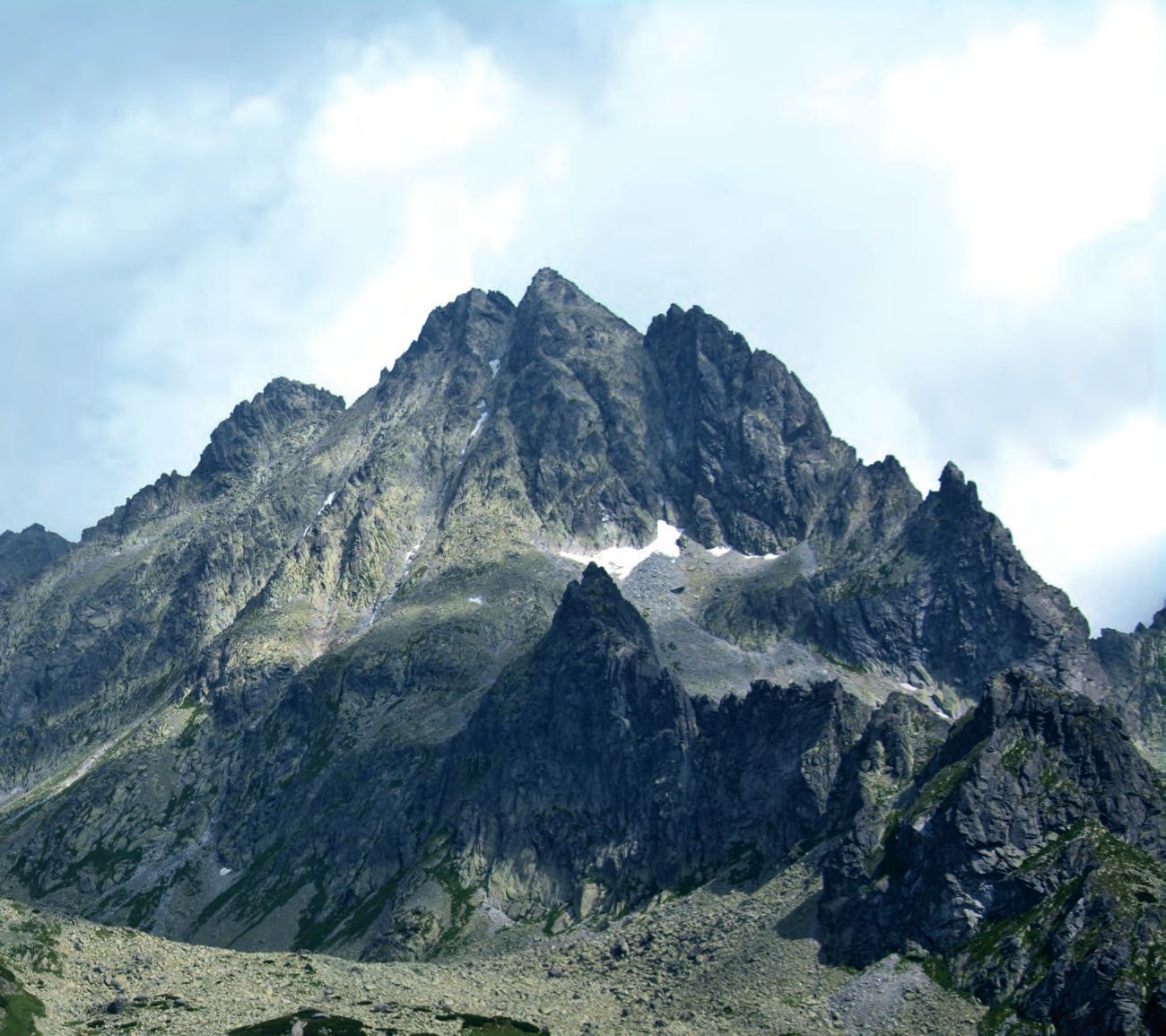 Ein Berg mit ein paar Wolken am Himmel.