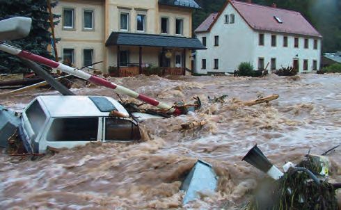 Ein überflutetes Gebiet mit einem Haus und einem Auto.