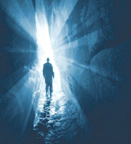 Ein Mann, der in einer Höhle steht, mit Licht, das von der Decke kommt.