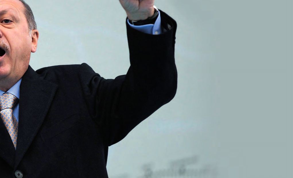 Ein Mann in Anzug und Krawatte, der die Hand hebt.