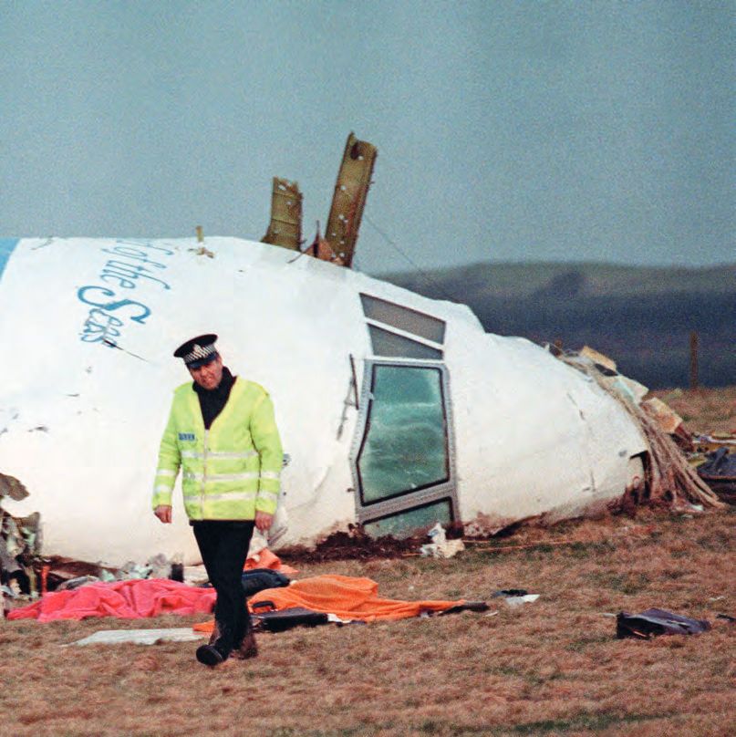 Ein Mann in Uniform, der vor einem Flugzeug vorbeigeht, das im Boden ist.