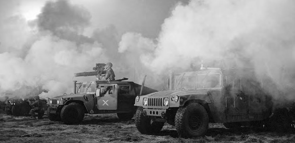 Ein schwarz-weißes Foto von Militärfahrzeugen mit Rauch aus ihnen.