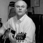Ein Mann, der eine Gitarre in den Händen hält.