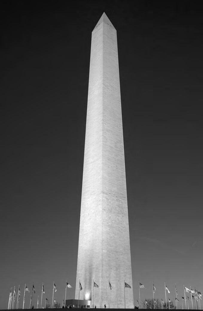 Ein großes weißes Denkmal mit vielen Flaggen vor ihm.