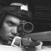Ein Mann mit einer Waffe auf einem schwarz-weißen Foto.