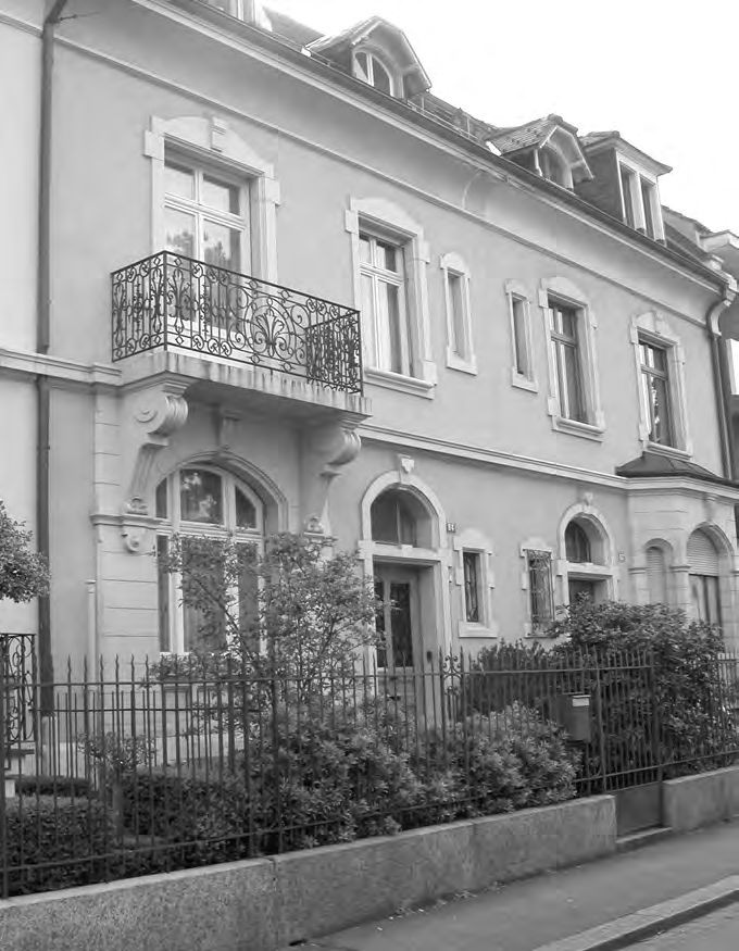 Ein Gebäude mit einem Zaun vor sich.