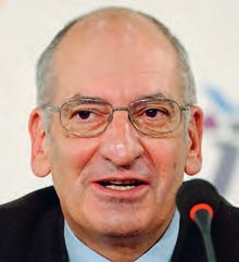 Ein Mann mit Brillen steht vor einem Mikrofon.