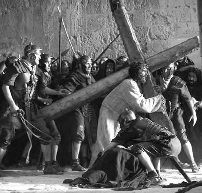 Eine Gruppe von Männer in Rüstung und mit einem großen Holzkreuz.