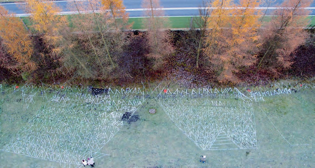 Eine Luftansicht auf ein Feld mit Bäumen im Hintergrund.