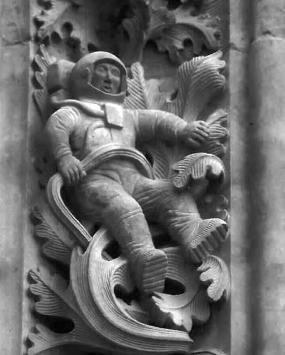 Eine Statue eines Mannes in einem Raumanzug an einer Wand.